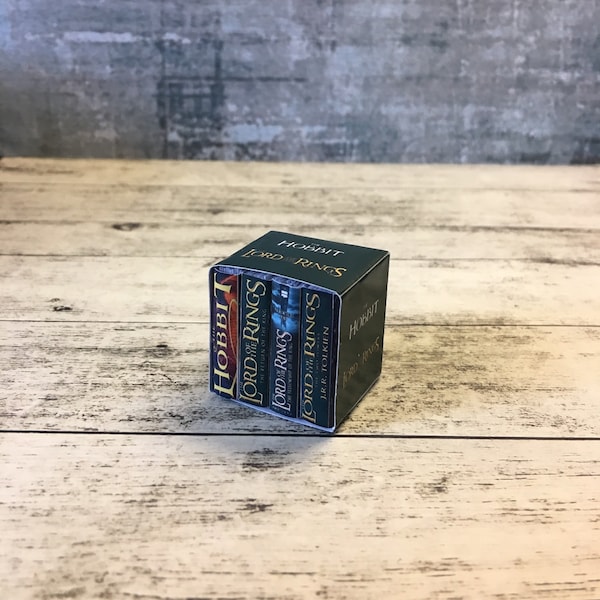 Könnte beinhalten: Ein Stapel von drei Miniatur-Hardcover-Büchern, Der Hobbit und Der Herr der Ringe, mit grünen Einbänden und goldenen Lettern.