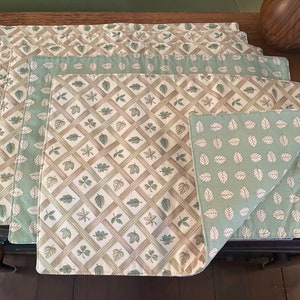 Peut inclure: Ensemble de six sets de table verts et bruns avec un motif de feuilles. Les sets de table sont en tissu et ont une texture tissée.