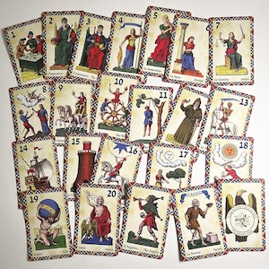 May include: A selection of tarot cards, each displaying unique illustrations and titles in different languages. The cards depict figures, symbols, and scenes, framed by a decorative border. The cards are arranged in a scattered pattern.