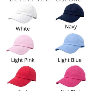 May include: Six infant hats in different colours: white, navy, light pink, light blue, red, and hot pink. The hats are all the same style, with a curved brim and a small logo on the front.