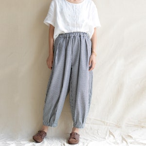 May include: Black and white gingham pants with an elastic waistband. The pants are loose fitting and have a wide leg.