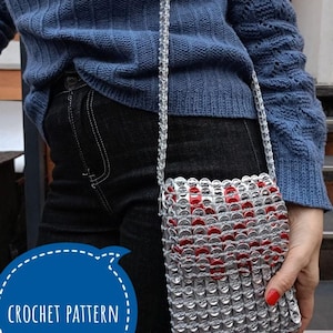 May include: A crochet pattern for a small, silver and red crossbody bag made from pull tabs. The bag has a silver chain strap and a red heart design.