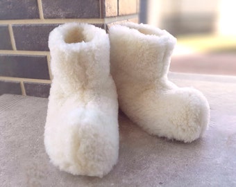 Pantoufles d'hiver blanches pour la maison. Chuni ukrainien chaud (chaussons en laine). Chaussures de maison en laine de mouton