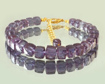 May include: A purple gemstone necklace with square-shaped beads and a gold clasp. The necklace is made of amethyst gemstones.