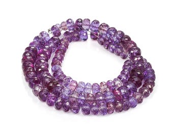 May include: Strands of faceted amethyst beads in varying shades of purple and violet. The beads are strung together, forming a necklace or bracelet. The gemstones have a polished, reflective surface.