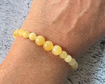 May include: A yellow gemstone bracelet with round beads.