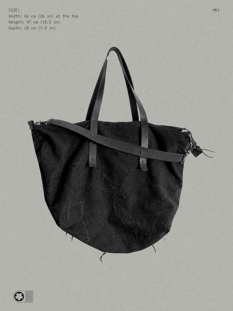 May include: A black tote bag with two top handles and a detachable shoulder strap. The bag features a textured fabric body and measures 66 cm wide at the top, 47 cm in height, and 20 cm in depth. The text M51 is visible at the top right corner.