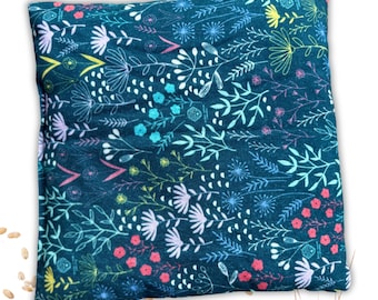 May include: A teal blue fabric pillow with a floral pattern in shades of pink, white, blue, and yellow. The pillow is filled with rice and can be heated in the microwave for a soothing heat therapy.