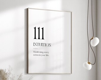 May include: A framed print with the number 111 and the word "INTUITION" in black text. The text below reads "Manifesting every action in your life." The print is hanging on a white wall above a green sofa.