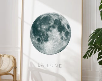 May include: A framed print with a large, detailed image of a full moon in shades of blue and gray. The text "LA LUNE" is printed below the moon.