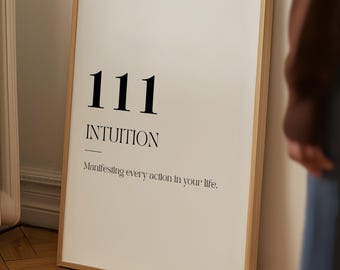 Könnte beinhalten: Ein gerahmter Druck mit weißem Hintergrund und schwarzem Text. Der Text lautet "111 INTUITION" mit dem Satz "Manifesting every action in your life" darunter. Der Rahmen ist hellbraun.