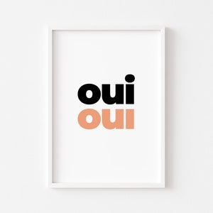 May include: A white framed print with the word "oui" in black and peach.