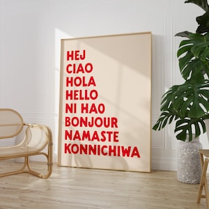 Peut inclure: Une affiche beige avec un cadre en bois, pr&eacute;sentant les mots "Hej", "Ciao", "Hola", "Hello", "Ni Hao", "Bonjour", "Namaste", et "Konnichiwa" en lettres rouges.