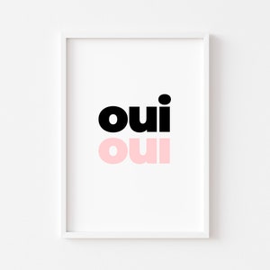 May include: A white framed print with the word "oui" in black and pink lettering. The word "oui" is repeated twice, once in black and once in pink.