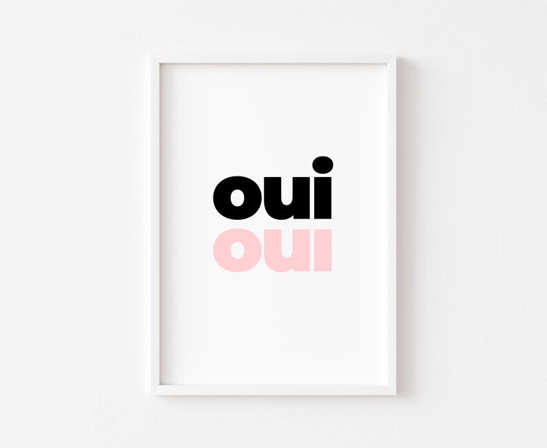 May include: A white framed print with the word "oui" in black and pink lettering. The word "oui" is repeated twice, once in black and once in pink.