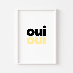 May include: A white framed print with the word "oui" in black and yellow lettering.