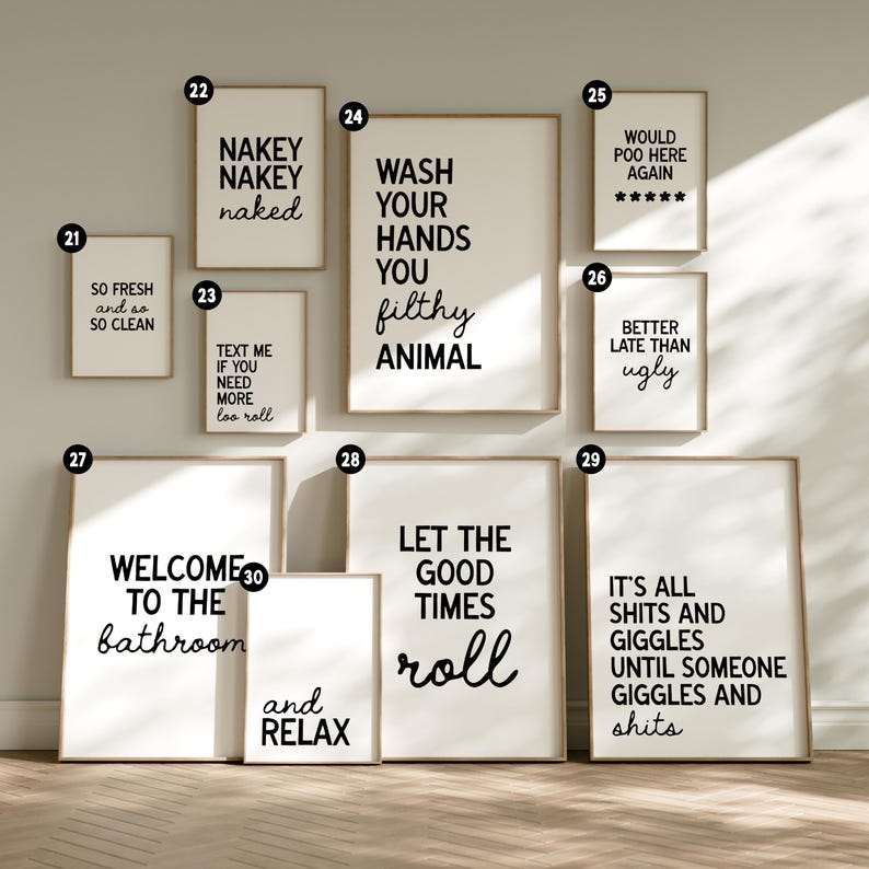 May include: A collection of framed bathroom art prints with humorous quotes in black text on white backgrounds. The prints include phrases like "Wash Your Hands You Filthy Animal" and "Welcome to the Bathroom."