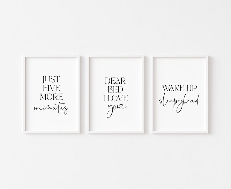 May include: Three white framed prints with black text. The first print says "Just five more minutes". The second print says "Dear bed I love you". The third print says "Wake up sleepyhead".