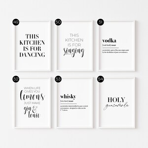 May include: Set of six white framed prints with black text. The prints feature kitchen-themed sayings and definitions of alcoholic beverages. The text includes "This kitchen is for dancing", "This kitchen is for singing", "Vodka", "When life gives you lemons, just make gin & tonic", "Whiskey", and "Holy guacamole".