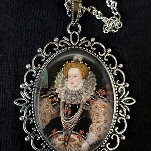 May include: Silver pendant necklace featuring a cameo of Queen Elizabeth I wearing a white lace ruff and pearl jewellery. The cameo is set in a silver oval frame with ornate scrollwork.