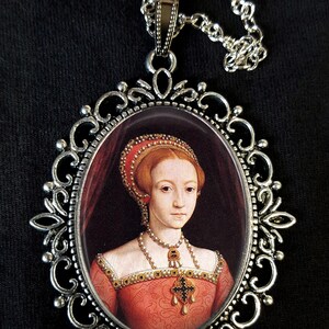 May include: A silver pendant necklace featuring a cameo of a woman in a red dress and a pearl necklace. The cameo is set within an ornate silver frame.