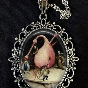 Peut inclure: Un collier en argent avec un pendentif ovale représentant une peinture d'une grande figure rose et bulbeuse entourée de plusieurs figures plus petites. Le pendentif est encadré d'une bordure argentée décorative.