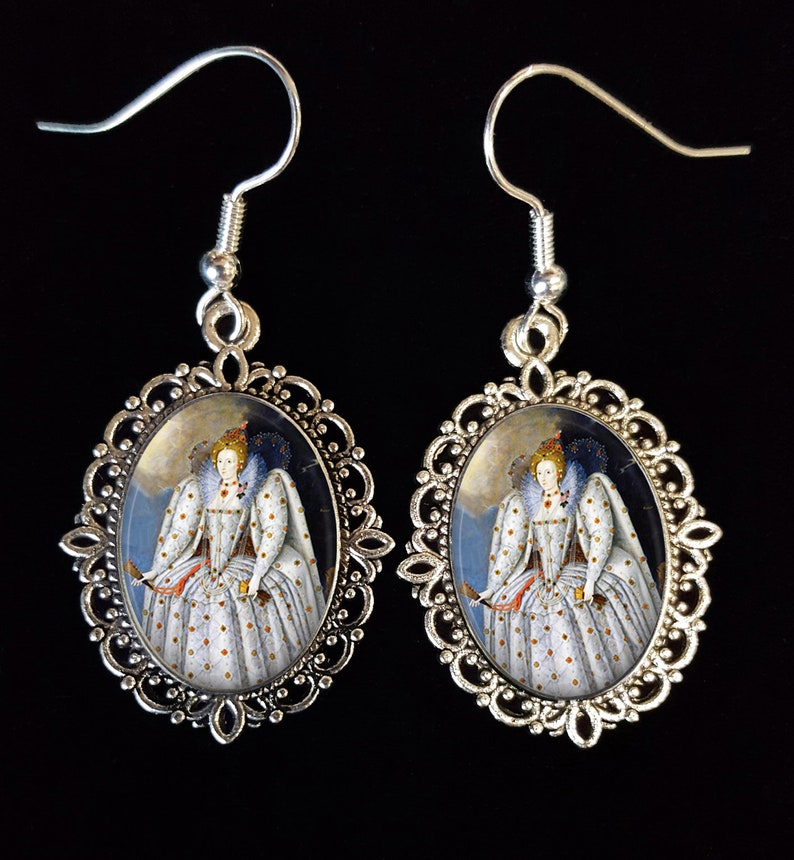 May include: Silver oval earrings featuring a portrait of Queen Elizabeth I in a white and gold dress against a blue background.