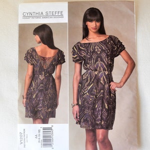 Puede incluir: Un patrón de costura para un vestido de Cynthia Steffe, una diseñadora estadounidense de Vogue Patterns. El patrón es para las tallas 6-8-10-12. El vestido es un vestido corto sin mangas con cuello redondo y falda fruncida. El vestido está impreso con un patrón abstracto negro y amarillo.