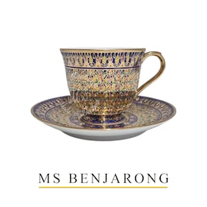 Puede incluir: Un juego de taza y platillo ornamentado con asa y borde dorados. La taza y el platillo presentan un patrón detallado en azul, dorado y otros colores. El texto "MS BENJARONG" está debajo.