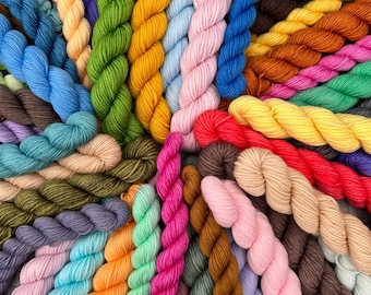 May include: A vibrant array of colorful yarn skeins arranged in a circular pattern. The skeins display a spectrum of hues, including blues, greens, pinks, yellows, and browns. The image showcases a variety of yarn for knitting or crochet projects.