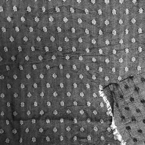 May include: Black and white fabric with a polka dot pattern. The fabric is textured and has a slightly rough feel.