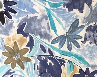 May include: A white fabric with a blue and brown floral pattern. The fabric has a watercolor-like effect and features a variety of flower shapes and sizes.