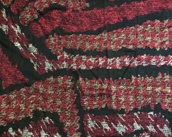 May include: Red, black, and gold fabric with a textured, abstract pattern. The fabric has a woven look and feel.