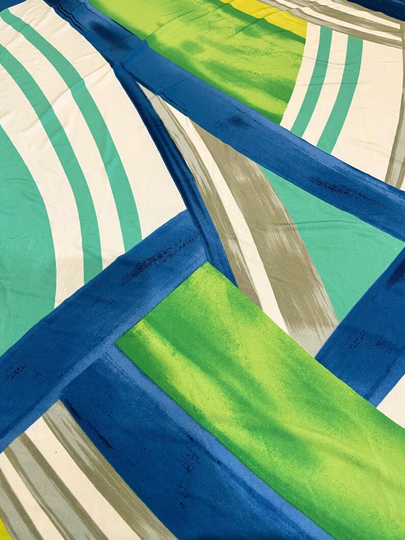 May include: Abstract geometric pattern fabric in shades of blue, green, white, and gray. The fabric features a diagonal striped pattern with a bold, graphic design.