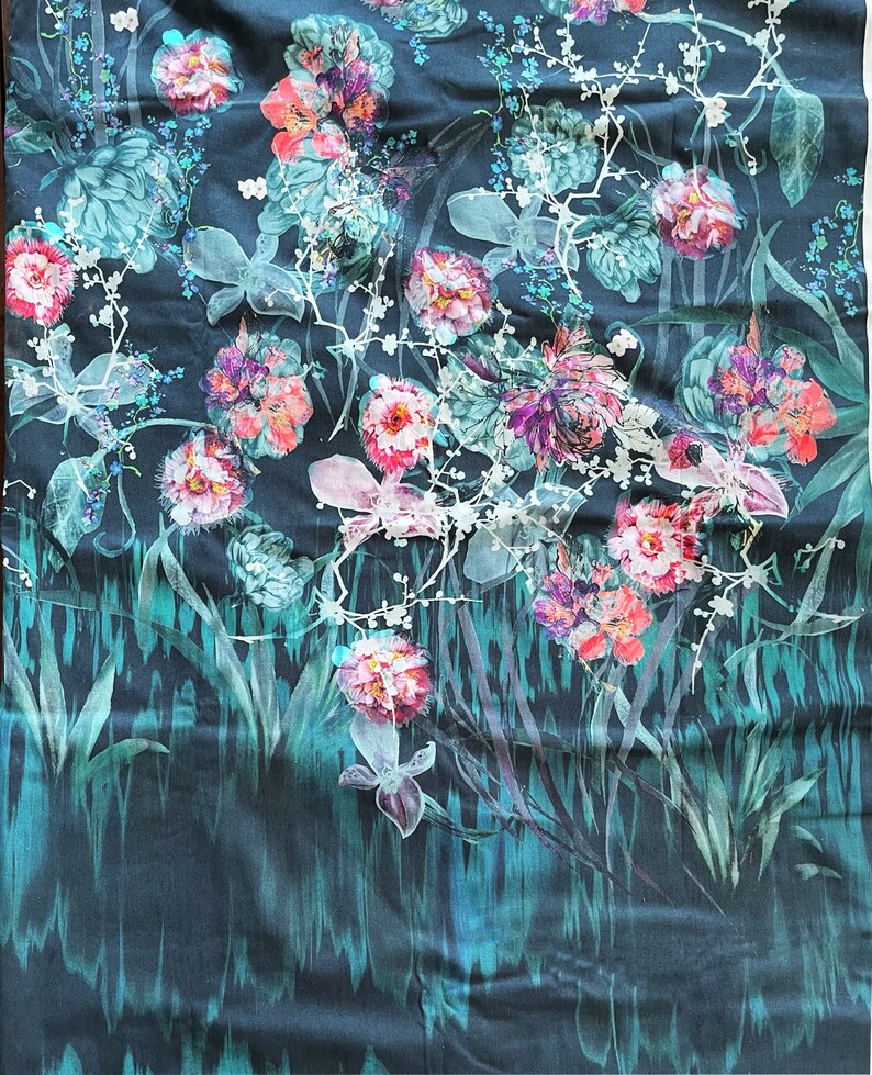 Pode incluir: Um tecido azul escuro com uma estampa floral com flores rosa, brancas e verdes. O tecido tem um aspecto texturizado e tecido.