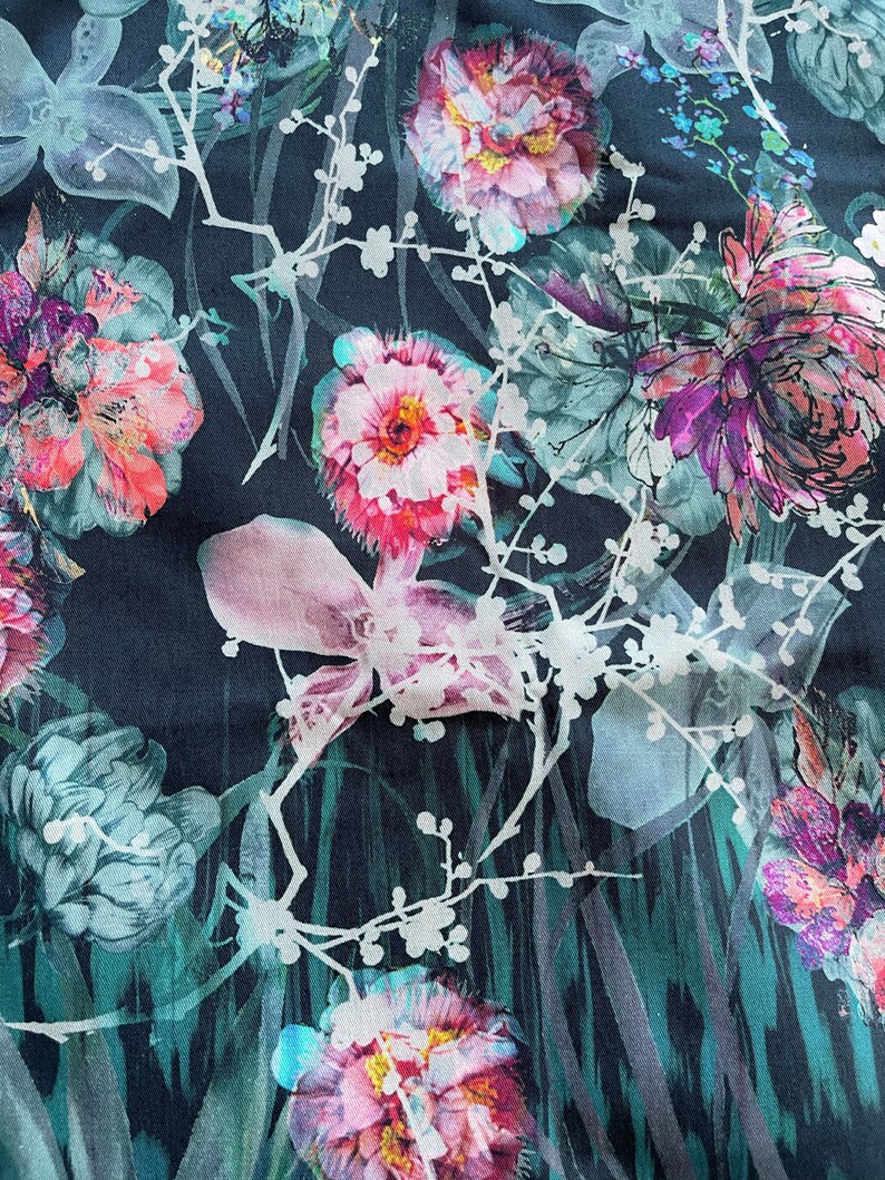 Pode incluir: Um tecido azul escuro com uma estampa floral com flores rosa, brancas e verdes. As flores s&atilde;o estilizadas e t&ecirc;m um efeito aquarela.