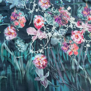 Pode incluir: Um tecido azul escuro com uma estampa floral com flores rosa, brancas e verdes. As flores s&atilde;o estilizadas e t&ecirc;m um efeito aquarela.