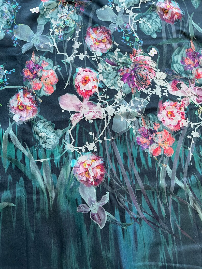 Pode incluir: Um tecido azul escuro com uma estampa floral com flores rosa, brancas e verdes. As flores s&atilde;o estilizadas e t&ecirc;m um efeito aquarela.