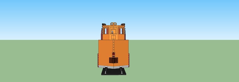 May include: A yellow and orange train engine with a black front bumper and a black roof. The engine has a single window on each side and a small door in the front.