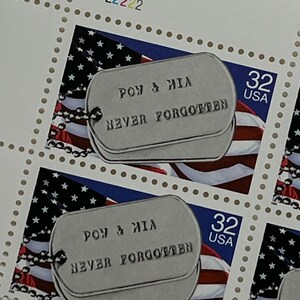 May include: Sheet of commemorative stamps featuring dog tag designs with the text "POW & MIA NEVER FORGOTTEN" over an American flag background. Each stamp is marked "32 USA".