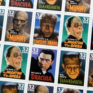 May include: A sheet of 32-cent USA postage stamps featuring classic horror movie characters including The Mummy, The Wolf Man, The Phantom of the Opera, Dracula, and Frankenstein, with each stamp displaying the character name and actor credit.