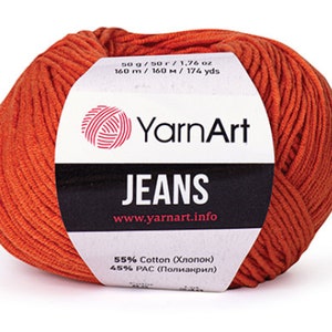 Peut inclure: Une pelote de fil orange étiquetée "YarnArt JEANS" avec le texte "50g/50г/1,76 oz 160 m / 160 м / 174 yds" et "55% Coton (Хлопок) 45% РАС (Полиакрил)" sur l'étiquette.