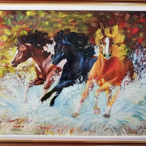 May include: Three horses running through a stream of water, splashing and kicking up white foam. The horses are brown, black, and orange with white markings. The background is a blur of yellow, green, and red.