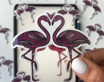May include: Two pink flamingo stickers with intricate black and white patterns, facing each other with their necks bent to form a heart shape. The stickers are on a white background.