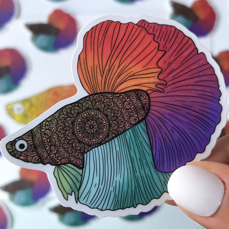 May include: A colorful sticker of a betta fish with a mandala pattern on its body. The fish is red, orange, purple, and blue.
