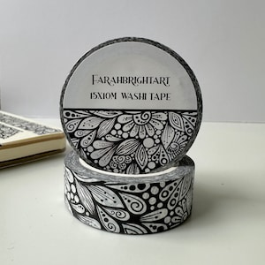 Pode incluir: Dois rolos de fita washi com padrão preto e branco. O rolo superior tem um rótulo que diz "FARAHBRIGHTART 15X10M WASHI TAPE".