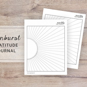 May include: Two white paper journals with a sunburst design and the words "Sunburst Gratitude Journal" printed on the cover. The journals are on a wooden surface. One journal is open, revealing a monthly habit tracker.