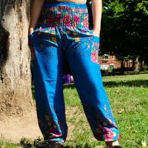 May include: Blue pants with a floral print. The pants have an elastic waistband and a loose fit.