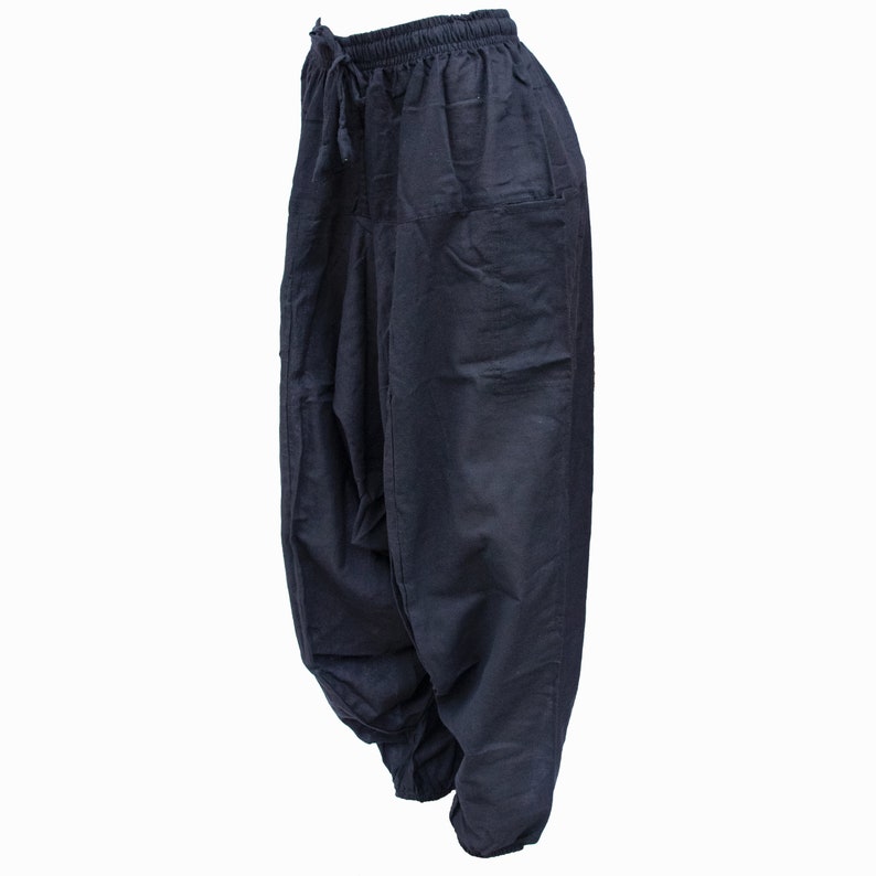 May include: Black cotton pants with a drawstring waist and a single pocket on the right side.