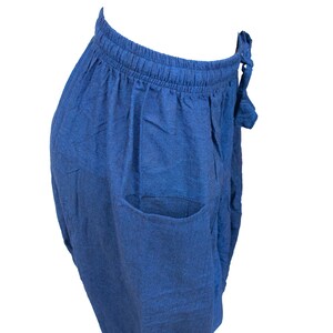May include: A pair of blue linen pants with a drawstring waist and a single pocket on the side.